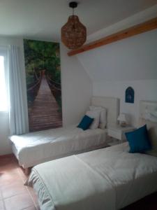 SWANARA HOLIDAYS في سارلا لا كانيدا: سريرين في غرفة مع لوحة على الحائط