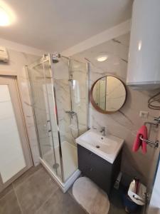 a bathroom with a shower and a sink and a mirror at Apartments Lana in Split