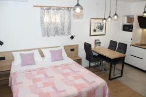 1 dormitorio con 1 cama y 1 mesa con sillas en Apartments Lana, en Split