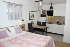 um quarto com uma cama, uma mesa e uma cozinha em Apartments Lana em Split