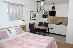 a bedroom with a bed and a table and a kitchen at Apartments Lana in Split