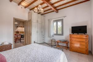 a bedroom with a bed and a flat screen tv at Lahardi - Seaside House in Kissamos