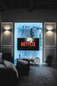 een woonkamer met een netflix-bord aan de muur bij BELVEDERE Luxury Apartment, view on the Lucca Walls in Lucca