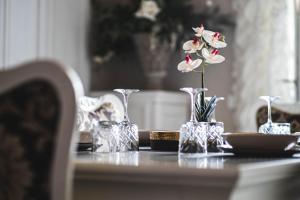 una mesa con tres jarrones de cristal con flores. en BELVEDERE Luxury Apartment, view on the Lucca Walls en Lucca