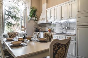 uma cozinha com armários brancos e uma mesa com cadeiras em BELVEDERE Luxury Apartment, view on the Lucca Walls em Lucca