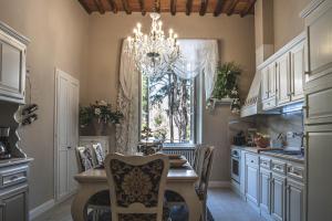 a kitchen with a dining table and a chandelier at BELVEDERE Luxury Apartment, view on the Lucca Walls in Lucca +29 photos