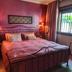 um quarto com uma cama grande e paredes vermelhas em Romantic white Villa -private pool em Nerja