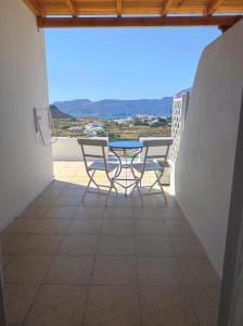 un balcon avec deux chaises et une table avec vue dans l'établissement Georgia Rooms Milos, à Plaka Milou