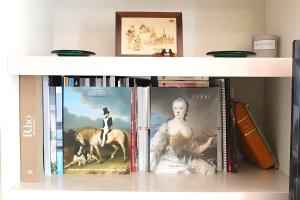 une étagère remplie de livres et d'images d'une femme dans l'établissement Central Park View Sinaia, à Sinaia