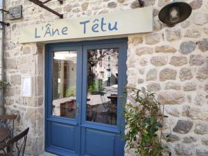 a blue door with a sign on a stone building at LAne Têtu in Désaignes