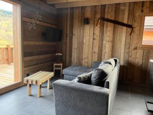 ein Wohnzimmer mit einem Sofa und einem Tisch in der Unterkunft Chalet L'Ôbresse in La Bresse