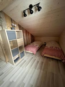 a room with two beds and a cabinet in a cabin at Chalet L'Ôbresse in La Bresse