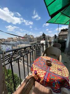 a table with an umbrella on top of a balcony at Cecilia Hostel in Cairo