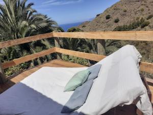 a bed on a deck with a view of the ocean at Casa Aura in Hermigua