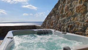 una bañera con agua junto a una pared de piedra. en Hotel Gorgona, en Mykonos ciudad