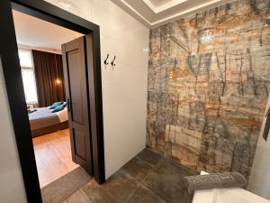 y baño con ducha y pared de piedra. en DK Premium Warmińska Secesja, en Olsztyn