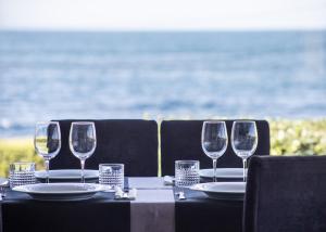 una mesa con cuatro copas de vino y platos en ella en Casa da Vasca, en Malpica de Bergantiños