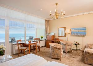 a living room with a table and a dining room at Strandhotel Monbijou GmbH garni in Westerland (Sylt)