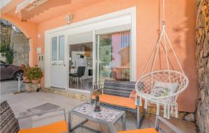 a porch with a swing and a table and chairs at Nice Apartment In Stara Baska With Wifi in Stara Baška