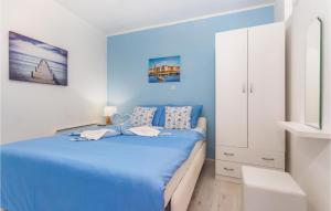 a blue bedroom with a bed and a white cabinet at Nice Apartment In Stara Baska With Wifi in Stara Baška