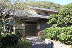 a dog sitting in front of a house at 6 min walk from JR. Entire Traditional House w/ Zen Garden 