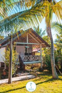 una casa con portico e palma di AQUARIUM MARGO Gili Air a Gili Air