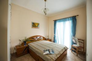a bedroom with a bed and a large window at Pantelis Apartments in Agios Georgios