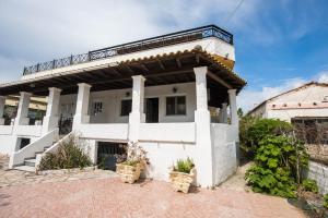 a white house with a balcony on top of it at Pantelis Apartments in Agios Georgios