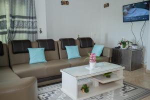 uma sala de estar com um sofá e uma mesa de centro em The city Block Apartment em Bujumbura