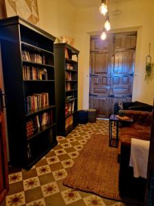 sala de estar con estanterías y sofá en Hosteria Casa Colonial, en Madrigal de la Vera