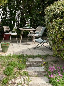 a patio with two chairs and a table and flowers at Atelier Soleil in Moustiers-Sainte-Marie