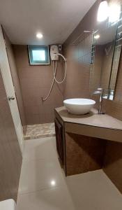 uma casa de banho com um lavatório e um espelho grande em Tientong Guesthouse em Hua Hin