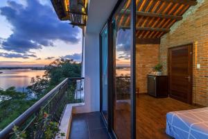 a house with a balcony with a view of the water at Calm House 2 HOSTEL in Hoi An