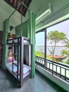a room with a balcony with a view of the ocean at Calm House 2 HOSTEL in Hoi An