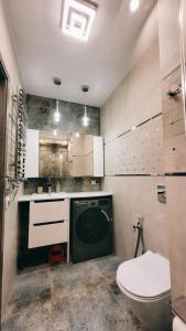 a bathroom with a washing machine and a toilet at Green Terrace Big Family Apartment in Wrocław