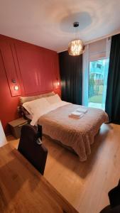 a bedroom with a large bed with a red wall at Green Terrace Big Family Apartment in Wrocław