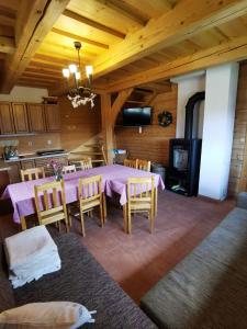 a dining room with a table and chairs and a fireplace at Drevenica Západné Tatry in Žiar