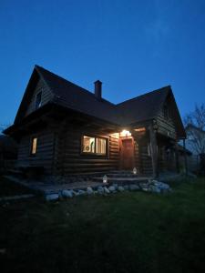 uma casa de madeira à noite com as luzes acesas em Drevenica Západné Tatry em Ziar