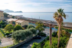 Blick auf den Ozean von einem Gebäude mit einer Palme in der Unterkunft Real Park Hotel in Cavi di Lavagna