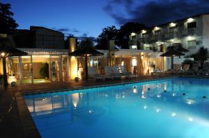 a large swimming pool in front of a hotel at night at Santa Cecilia Resort & Spa I in Villa Carlos Paz