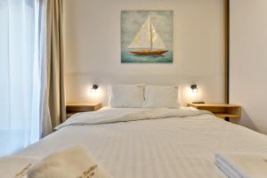 ein Schlafzimmer mit einem weißen Bett mit einem Segelboot darauf in der Unterkunft Vila Zlatibor luxury & spa in Zlatibor