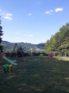 un parco con un mucchio di attrezzature da parco giochi nell'erba di Le belvédere Mouxois, SPA privatif, vue Morvan a Moux-en-Morvan