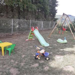 a playground with a slide and a swing set at Le belvédere Mouxois, SPA privatif, vue Morvan in Moux-en-Morvan