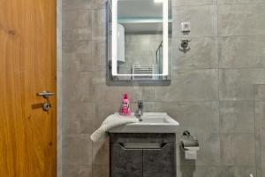 ein Badezimmer mit Waschbecken und Spiegel in der Unterkunft Vila Zlatibor luxury & spa in Zlatibor + 20 Fotos