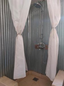 ‘Izbat an Nāmūs的住宿－Barefoot by Barefoot in Tunis，浴室设有两扇白色窗帘,配有淋浴