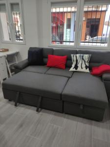 a gray couch with red pillows in a living room at Melania House in Candeleda