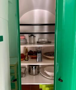 spiżarnia z jedzeniem i naczyniami na półkach w obiekcie Terrazza Diomede- Manfredi Homes & Villas w mieście Manfredonia