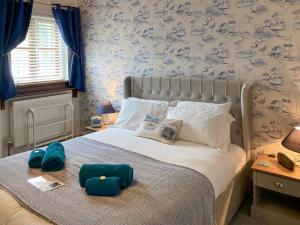 a bedroom with a large bed with blue wallpaper at The Boathouse in Appledore