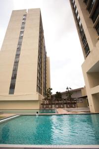 a person standing in a swimming pool in front of a building at Paradigm Residence By The one - upstair of paradigm mall JB in Johor Bahru