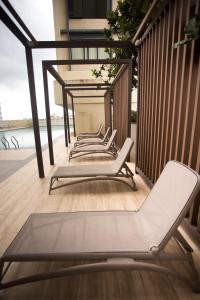 a row of lounge chairs sitting on a balcony at Paradigm Residence By The one - upstair of paradigm mall JB in Johor Bahru